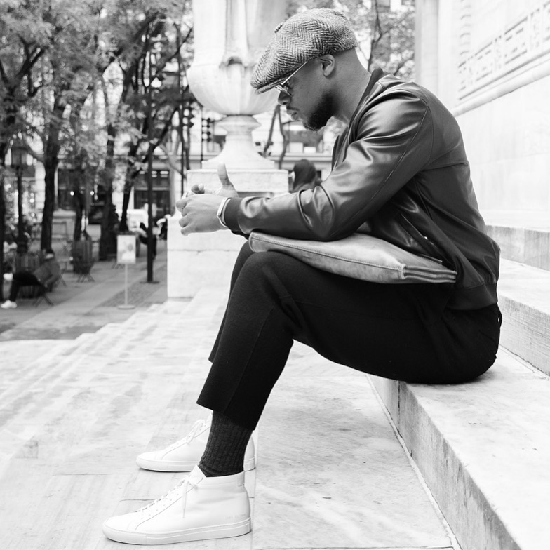 Jason Rosario seated on the steps, contemplative